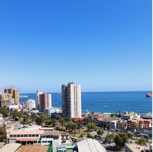 un perfil urbano con el océano en el fondo en Departamento en Antofagasta 2D+1B FULL en Antofagasta