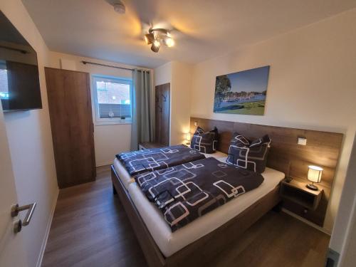 Un dormitorio con una cama grande en una habitación. en Strandkajüte Hooksiel, en Wangerland