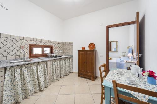 una cucina con bancone, tavolo e lavandino di Casa Liori a Dolianova