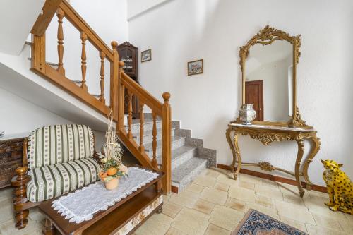 ein Wohnzimmer mit einer Treppe und einem Spiegel in der Unterkunft Casa Liori in Dolianova
