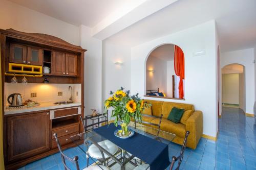 a living room with a couch and a table with flowers at Amalfi Residence in Conca dei Marini