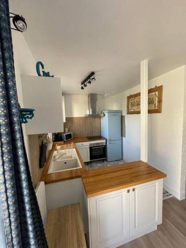 Elle comprend une petite cuisine avec des placards blancs et un réfrigérateur bleu. dans l'établissement Stade Rochelais, à La Rochelle