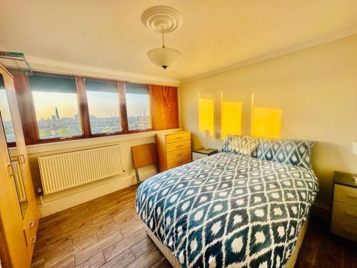 a bedroom with a bed and a large window at 3 bed Sky apartment SE15 Peckham in London