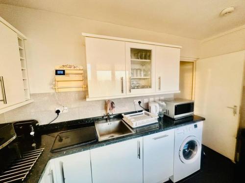 a kitchen with a sink and a washing machine at 3 bed Sky apartment SE15 Peckham in London