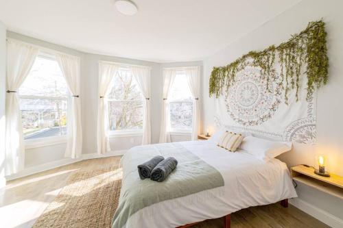 een witte slaapkamer met een groot bed en ramen bij Sunshine Central - Yale 3BR Prking Wshr/Dryr in New Haven