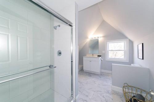 een witte badkamer met een douche en een wastafel bij Sunshine Central - Yale 3BR Prking Wshr/Dryr in New Haven