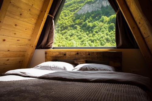 a bed in a room with a large window at Natures Escape Kozarica in Šavnik