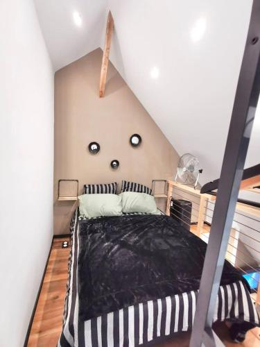 - une chambre mansardée avec un lit noir et blanc dans l'établissement LE NID DE LA TOURELLE - Wifi - Hôpital - IUT, à Quimper