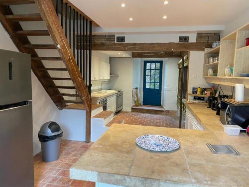 une cuisine avec un escalier et une table avec une assiette dans l'établissement La maison d'Athénaïs, à Gondrin