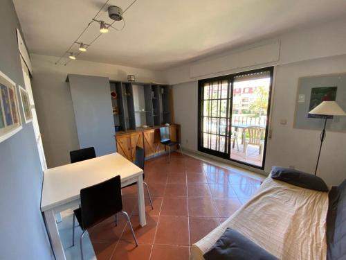 uma sala de estar com uma mesa e um sofá em Alcaudón 1 dormitorio by SIT ISLA CANELA em Isla Canela