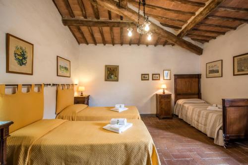 a room with two beds in a building with wooden ceilings at Tinaia in Siena