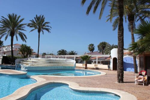 einen Pool mit einem Brunnen und Palmen in der Unterkunft Apartments Llagosta 3 in Denia