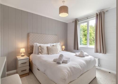 a bedroom with a large white bed with a window at The Essex Golf And Country Club 