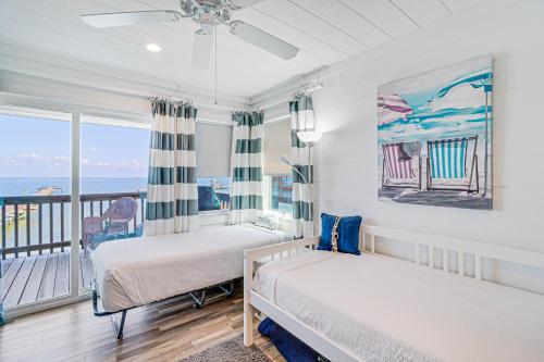 a bedroom with two beds and a balcony with the ocean at The Ridge in Rockport