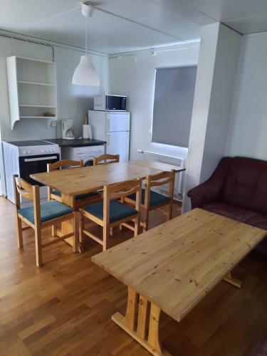 uma cozinha com uma mesa de madeira e cadeiras num quarto em Vinland Apartment 1 em Egilsstadir