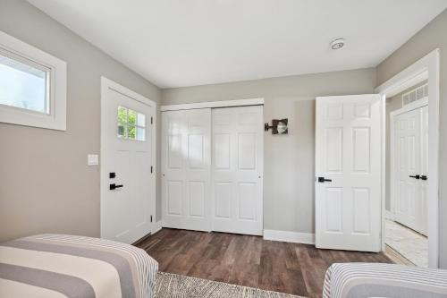 a bedroom with white doors and wood floors at Charming Contemporary Family Home home in Glenview