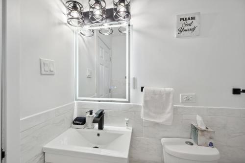 a white bathroom with a sink and a toilet at Charming Contemporary Family Home home in Glenview