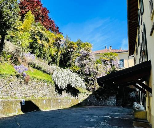 a stone wall with flowering trees and a building at BELLE ILE PARK in Griante Cadenabbia