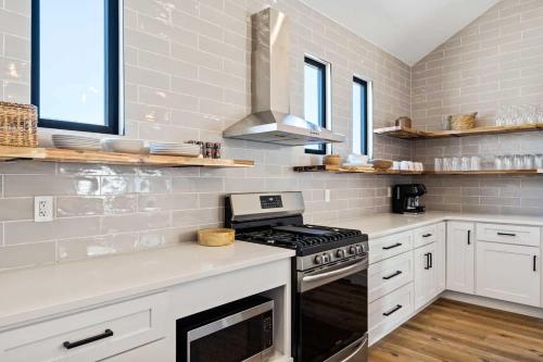 une cuisine avec des armoires blanches et un four à plaques de cuisson dans l'établissement Desert Bungalow #H8 home, à Hurricane