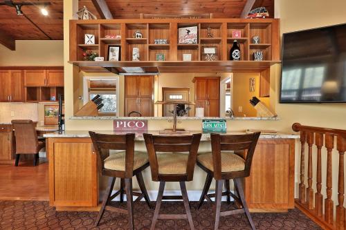 a kitchen with a bar with wooden cabinets at Alpine Court Chalet home in Killington
