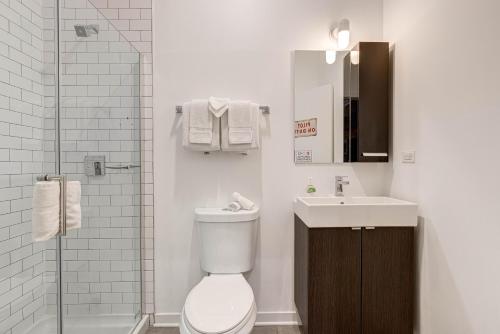 een badkamer met een toilet, een wastafel en een douche bij Cabin 105 by 747 Lofts in Chicago