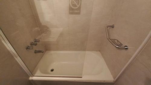 a bathroom with a shower with a bath tub at Costanera Hotel in Puerto Madryn