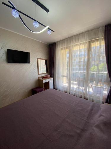 a bedroom with a large bed and a window at Apartment Veronika in Sozopol