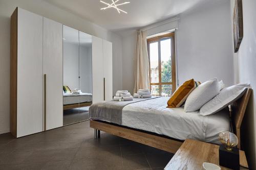 1 dormitorio con cama y ventana grande en MONZA-MILANO - Comfort tra centro e stazione - WIFI en Monza