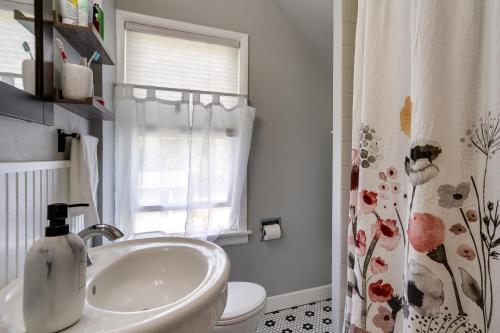 a bathroom with a sink and a toilet and a window at Pet-Friendly Saint Paul Home - Near Allianz Field! in Saint Paul