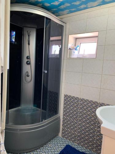 a shower with a glass door in a bathroom at Guest House ak orgo in Bishkek