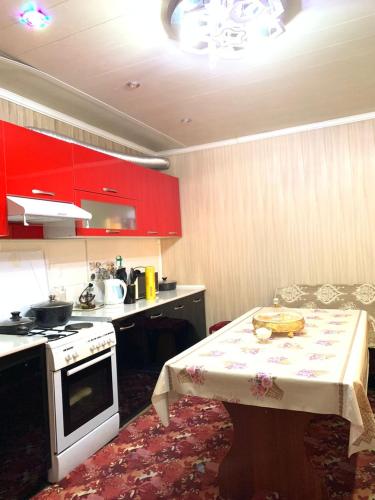 a kitchen with red cabinets and a table with a plate on it at Guest House ak orgo in Bishkek
