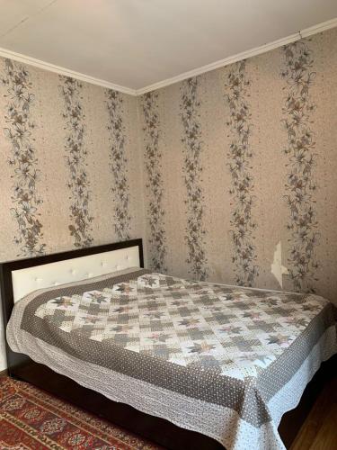 a bedroom with a bed with a checkeredkered wall at Guest House ak orgo in Bishkek