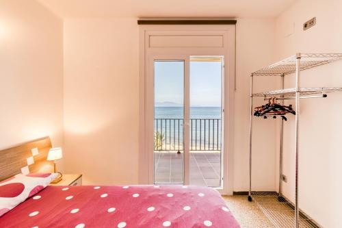 una camera da letto con un letto e vista sull'oceano di Riells Platja a L'Escala