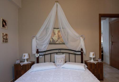 Antique Apartment في أفيتوس: غرفة نوم بها سرير مظلة مع مصباحين