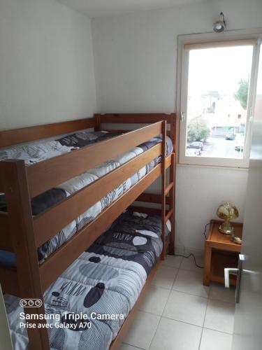 deux lits superposés dans une chambre avec fenêtre dans l'établissement Coquet Studio Centre Port Cap D'Agde, au Cap d'Agde