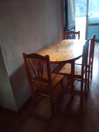 uma mesa de madeira com duas cadeiras e uma mesa de madeira e uma mesa e uma espreguiçadeira em Casita con vista a la montaña em Icod de los Vinos