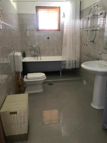 a bathroom with a tub and a toilet and a sink at Six bedroom Holiday home Matea in Ploče
