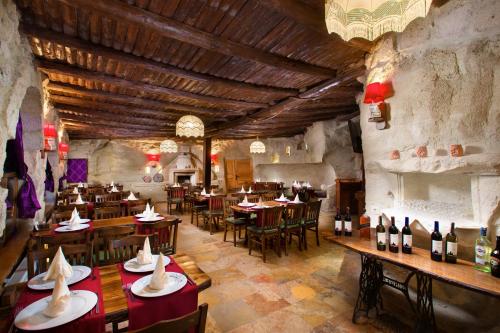 a restaurant with tables and chairs and wine bottles at Cappadocia Splendid Cave Hotel in Ortahisar