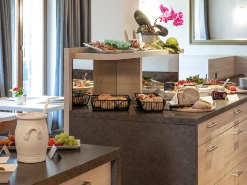 a kitchen with a counter with bread and vegetables in baskets at Hotel B&B Martha in Brunico