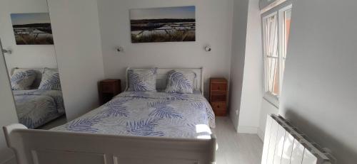 une chambre avec un lit avec une couette bleue et blanche dans l'établissement Centre ville à 2 pas de la plage, à Pornichet