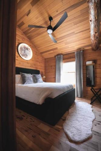 a bedroom with a bed and a ceiling fan at Lake View Cozy Cabin Hocking Hills with Pond and Hot Tub in Rockbridge