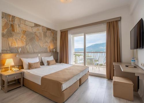 - une chambre avec un grand lit et une grande fenêtre dans l'établissement Trendlife Hotels Torba, à Bodrum City