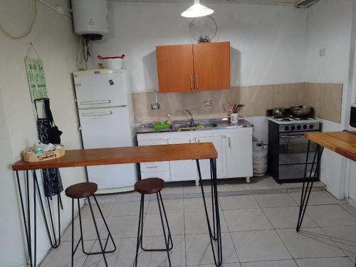 a kitchen with a table and two stools in it at El séptimo día, lugar de descanso in Funes