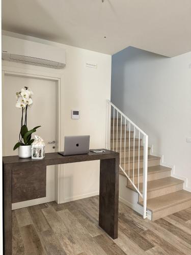 a room with a desk with a laptop and stairs at Ca' Maggiolo in Cinto Caomaggiore