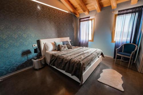 1 dormitorio con 1 cama y 1 silla en Bed & Breakfast Gioia di..., en Santo Stino di Livenza
