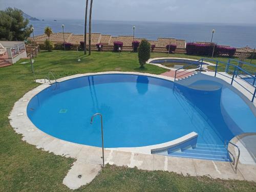 an overhead view of a large blue swimming pool at ADNANIa 2023 in La Herradura