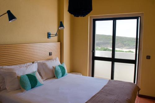 um quarto com uma cama grande e uma janela grande em WOT Sintra Ocean em Sintra