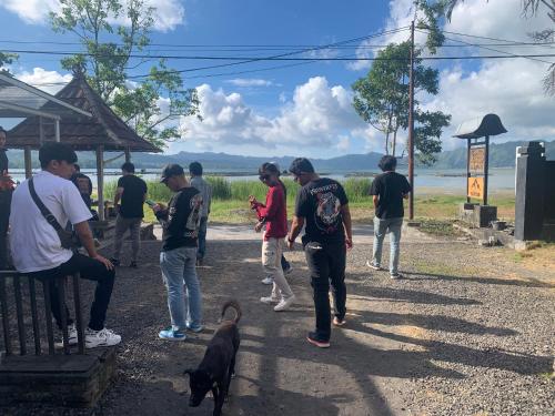 a group of people walking a dog on a road at Buahan Sweet Glamping ( BSG) in Kubupenlokan