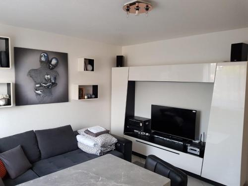 uma sala de estar com um sofá e uma televisão de ecrã plano em Eneya em Rotemburgo do Fulda