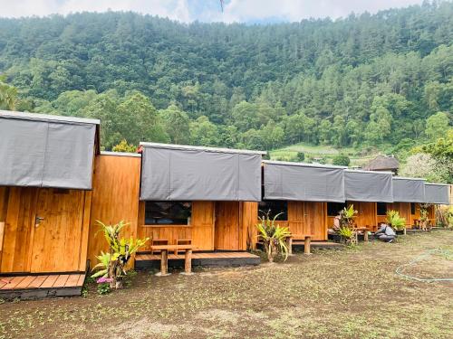 a row of wooden buildings with tarps on them at Buahan Sweet Glamping ( BSG) in Kubupenlokan